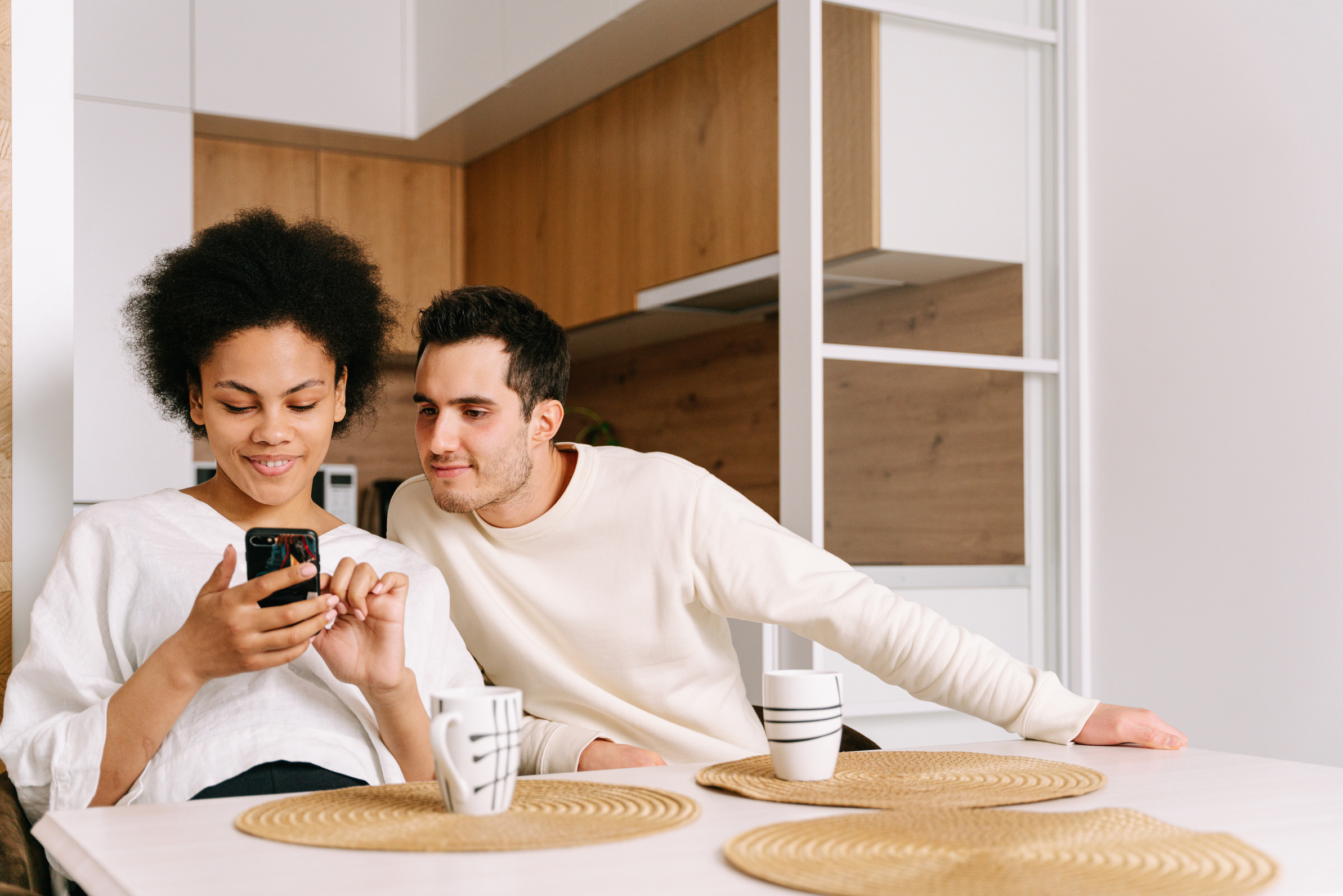 Duas pessoas acompanhando uma conversa no celular